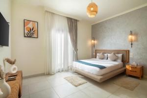 a bedroom with a bed and a large window at The Avenue in El Alamein