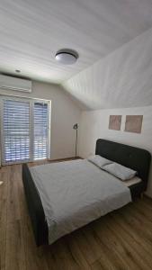 a bedroom with a large bed and two windows at Vila Castrum in Nové Zámky