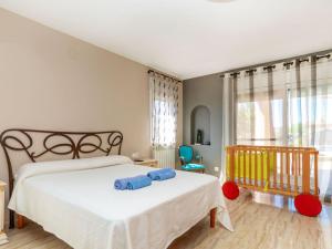 a bedroom with a white bed and a crib at Villa Villa Cantos by Interhome in L'Ametlla de Mar
