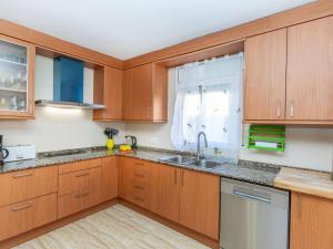 a kitchen with wooden cabinets and a sink at Villa Villa Cantos by Interhome in L'Ametlla de Mar