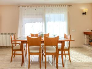 a dining room with a wooden table and chairs at Villa Villa Cantos by Interhome in L'Ametlla de Mar