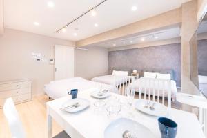 a white room with two beds and a dining table at ベルビー川崎 in Kawasaki +119 photos