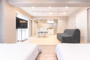 a bedroom with two beds and a living room at ベルビー川崎 in Kawasaki