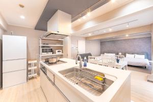 a kitchen with a sink and a room with a bed at ベルビー川崎 in Kawasaki