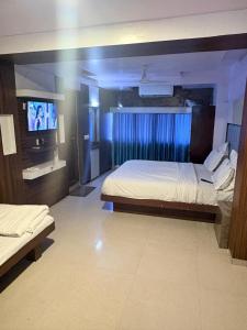 a hotel room with two beds and a television at Hotel keshav in Ahmedabad +2 photos