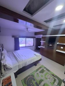 a bedroom with a large bed and a large window at Hotel keshav in Ahmedabad