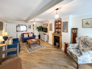 a living room with blue furniture and a fireplace at St Augustine's Stays - Stone Bay in Broadstairs
