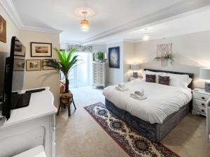 a bedroom with a bed and a desk and a tv at St Augustine's Stays - Stone Bay in Broadstairs