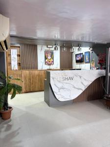 a hotel masashi counter in a room with a plant at Hotel keshav in Ahmedabad