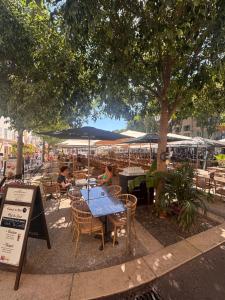 an outdoor restaurant with tables and chairs under a tree at Le Pavillon du Cap d'Antibes in Antibes