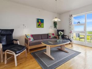 a living room with a couch and a table and chairs at Apartment Sofija by Interhome in Højer
