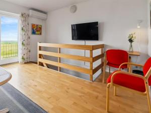 a living room with a television and red chairs at Apartment Sofija by Interhome in Højer +20 photos