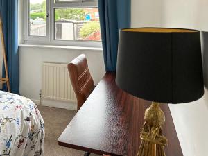 a lamp sitting on a wooden table in a bedroom at Views Wood in Uckfield