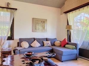 a living room with a blue couch and a table at Holiday Home Dorenavant by Interhome in Bouveret