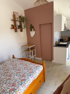 a bedroom with a bed and a small kitchen at Studio cozy 2pp wifi in La Sicaudais