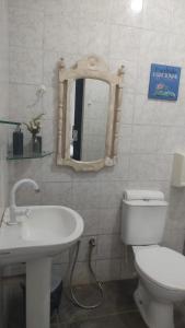 a bathroom with a toilet and a sink and a mirror at Urca do Tubarão in Touros +12 photos