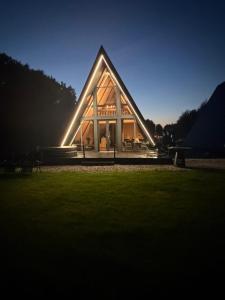 a large house with a triangular roof at night at Devi retreat in Arpaşu de Sus