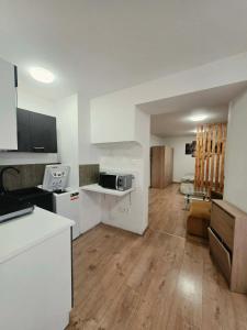 a kitchen and living room with white walls and wooden floors at Apartmán Gabriel in Kežmarok