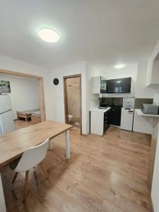 a kitchen and dining room with a wooden table at Apartmán Gabriel in Kežmarok +10 photos