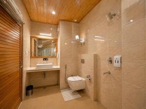 a bathroom with a toilet and a sink at The Tanwar Villas in Manāli