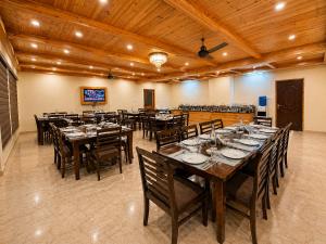 a large dining room with wooden tables and chairs at The Tanwar Villas in Manāli