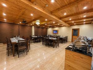 a dining room with tables and chairs and wooden ceilings at The Tanwar Villas in Manāli +18 photos