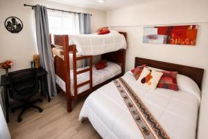 a bedroom with two bunk beds and a desk at Milagro Andino in Arica