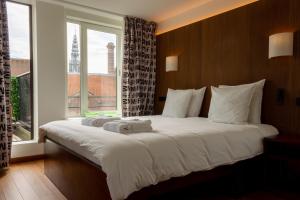 a large bed in a room with a large window at Hotel The Exchange in Amsterdam