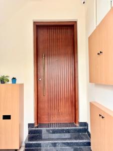 a wooden door in a room with stairs at Meadows Homestay Elite in Madurai +65 photos