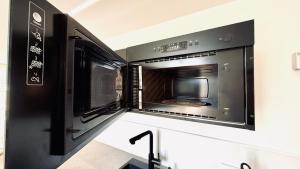 a microwave oven with a tv in a kitchen at Studio Premium Climatisé in Avallon