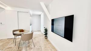 a living room with a table and a tv on a wall at Studio Premium Climatisé in Avallon