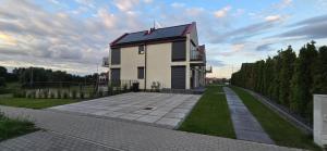 a house with a brick driveway in front of it at Villa nad stawem in Pszczew