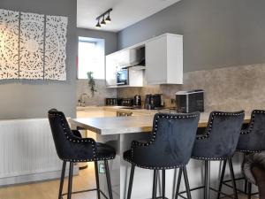 a kitchen with black bar stools and a counter at Doodles Holiday Home in Eyemouth +5 photos