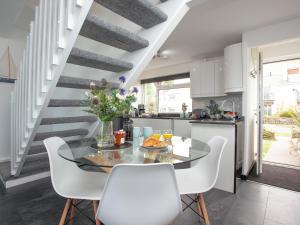 a kitchen and dining room with a glass table and white chairs at Chacewater in Newquay