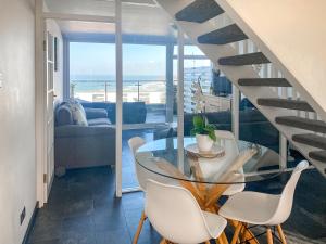 a dining room with a glass table and white chairs at Chacewater in Newquay