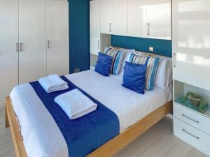a bedroom with a large white bed with blue pillows at Chacewater in Newquay +11 photos