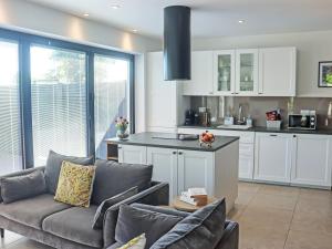 a living room with a couch and a kitchen at Deerview Lodge - Uk51044 in Bonvilston