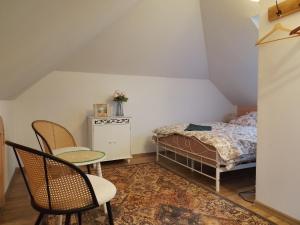 ein Schlafzimmer mit einem Bett, zwei Stühlen und einem Tisch in der Unterkunft Folwark Miodobytek in Łomnica