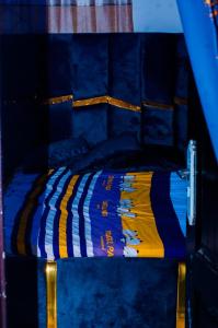 a blue bunk bed with a striped bedspread on it at BP Aura Stay in Akitan