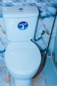 a white toilet with a sign on the side of it at BP Aura Stay in Akitan