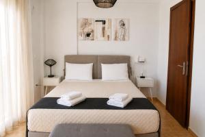 a bedroom with a bed with two towels on it at Lagouvardos Beach Apartments in Marathopoli