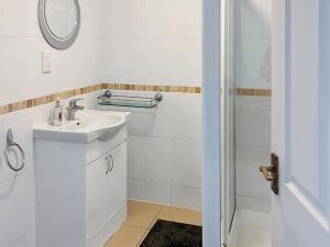 a white bathroom with a sink and a shower at Mistletoe No3 -Uk49252 in Althorne
