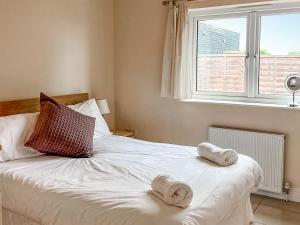 a bedroom with a bed with two towels on it at Mistletoe No3 -Uk49252 in Althorne +2 photos