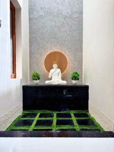 a statue of a buddha sitting in a room at Meadows Homestay Elite in Madurai