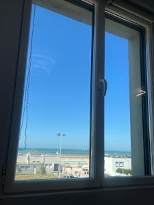 a window with a view of the beach at Studio Aloe horizon in Dunkerque