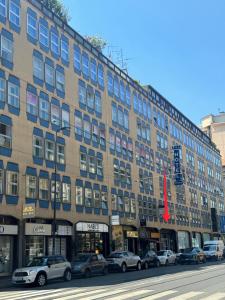 a large building with cars parked in front of it at CP Hotels - Central in Milan