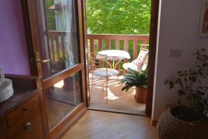 an open door to a balcony with a table and chairs at Casa del Zefiro in Sistiana +54 photos
