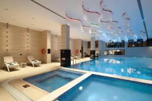 a large swimming pool in a hotel with a chandelier at Grand Bloom Hotel in Baghdād