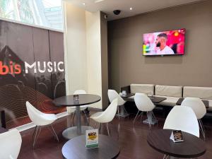 a restaurant with tables and chairs and a tv on the wall at Ibis Monterrey Valle in Monterrey