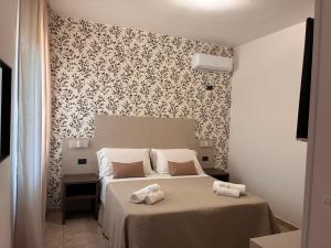 a bedroom with a bed and a black and white wallpaper at Hotel Paradiso 1972 in Schiavonea
